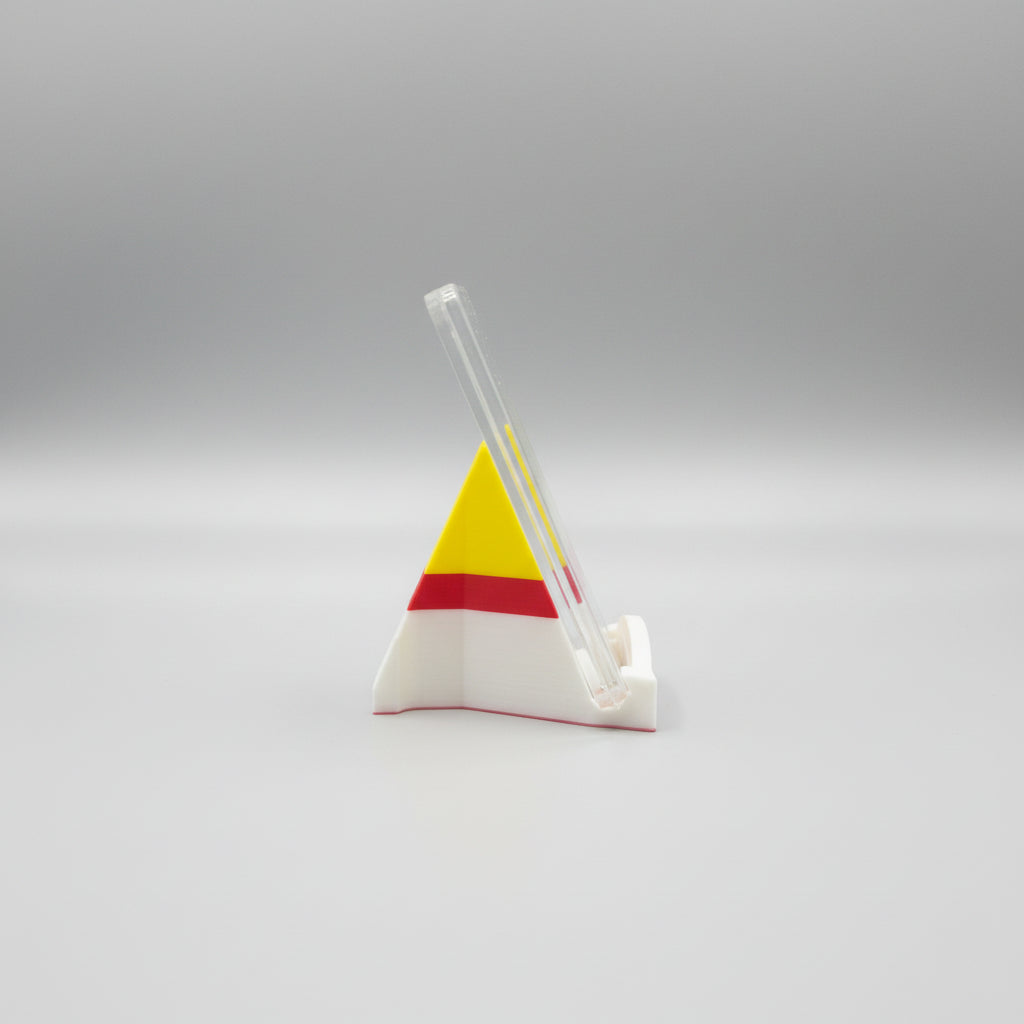 Colorful triangle-shaped object on a marble surface with a laptop in the background