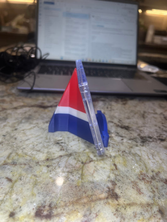 Colorful plastic triangle on a marble surface with a laptop in the background