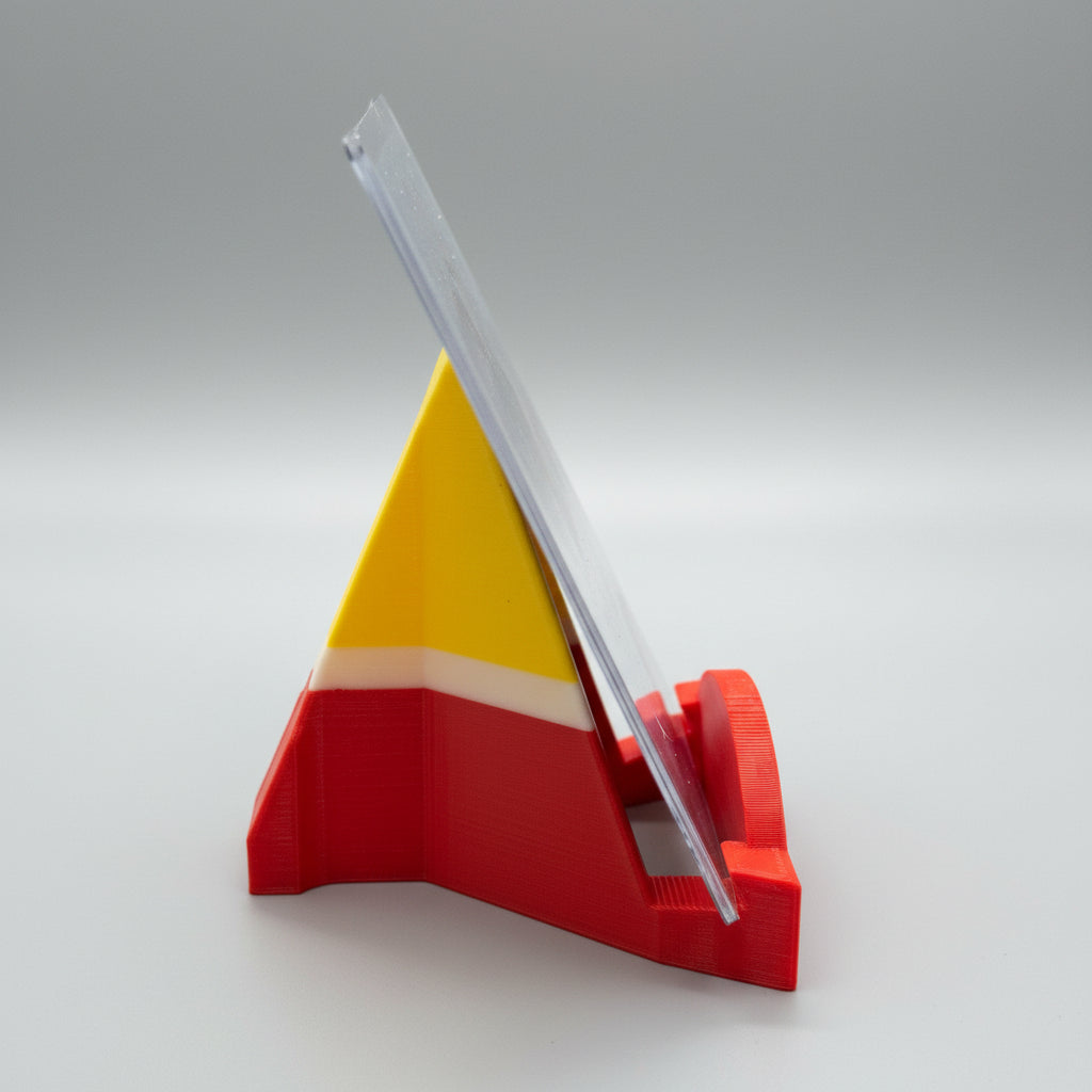 Red and yellow plastic stand holding a clear plastic sheet on a metallic surface.