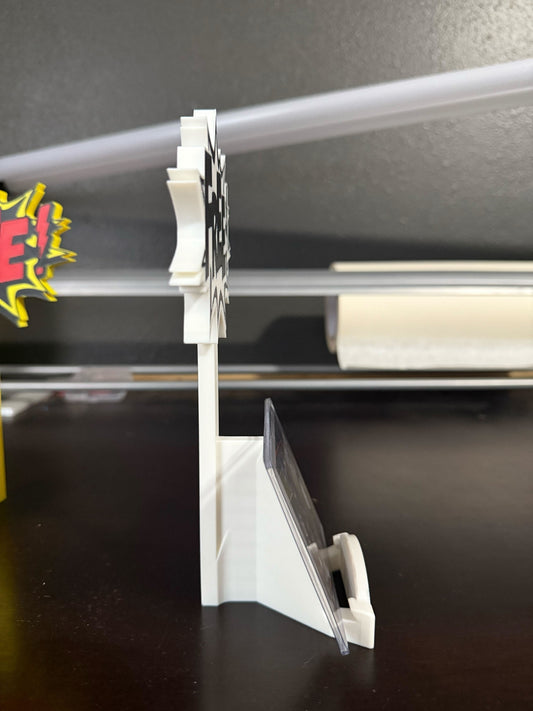 White plastic stand with a clear ruler on a dark surface