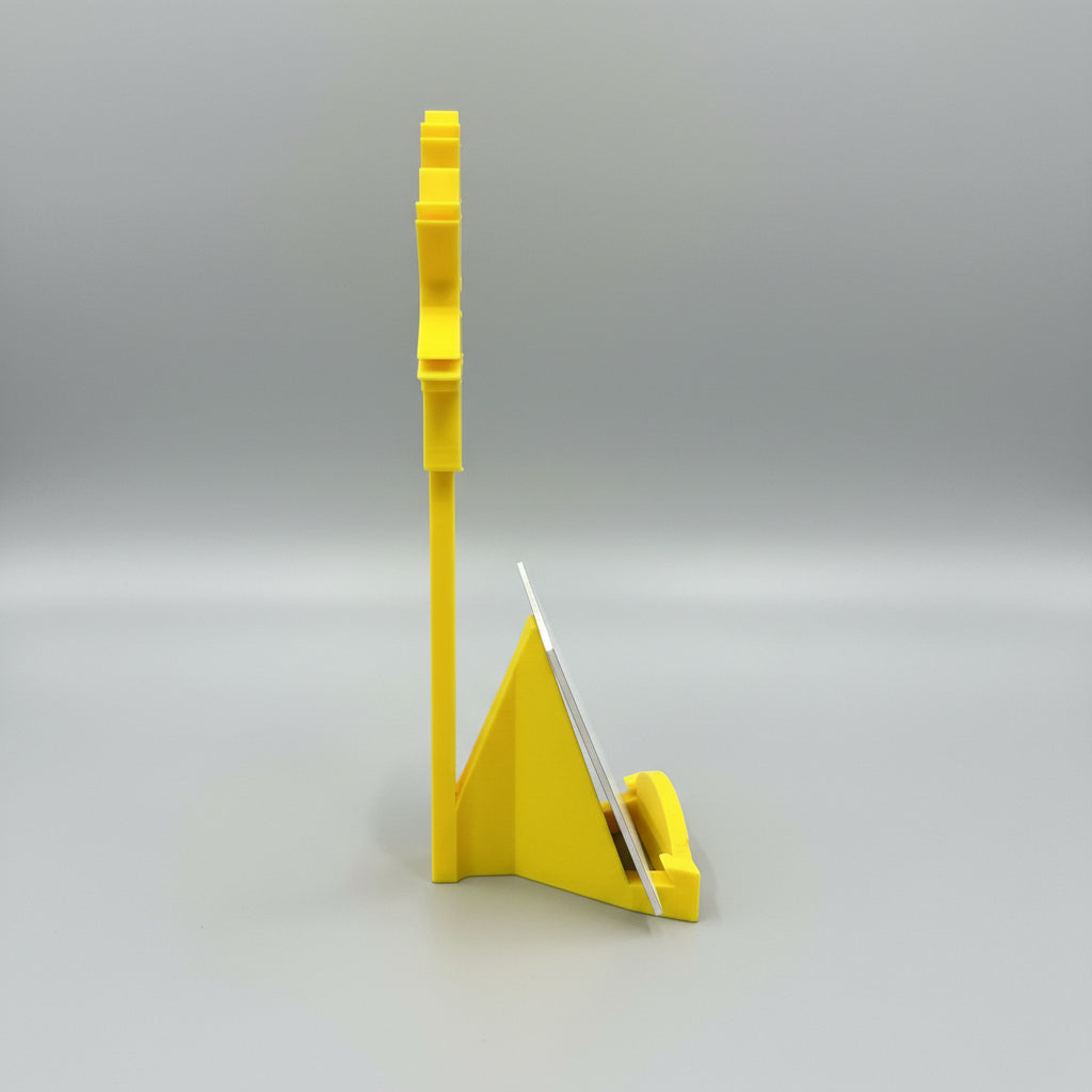 Yellow plastic stand with a metal blade on a dark surface