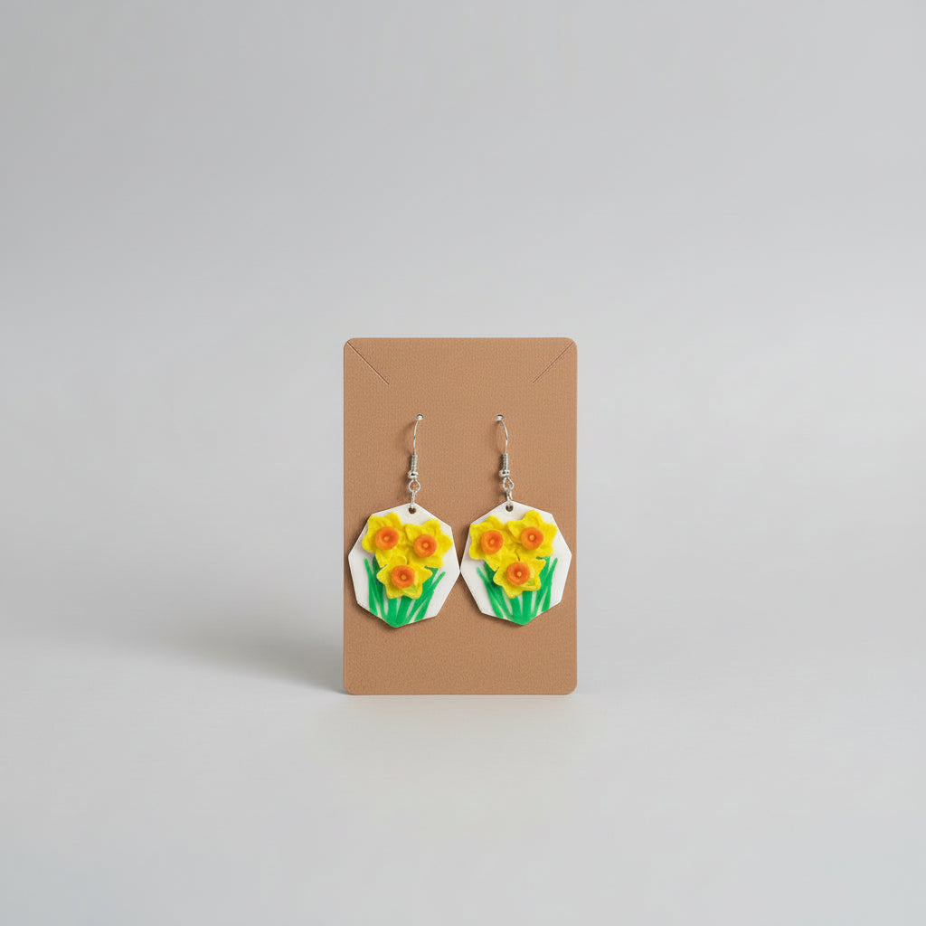 Floral earrings on a cardboard backing against a gray background