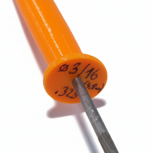 Orange cylindrical object with measurement markings and a metal tool on a textured surface