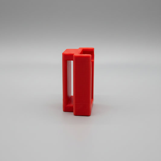 Red plastic tool on a textured metallic surface