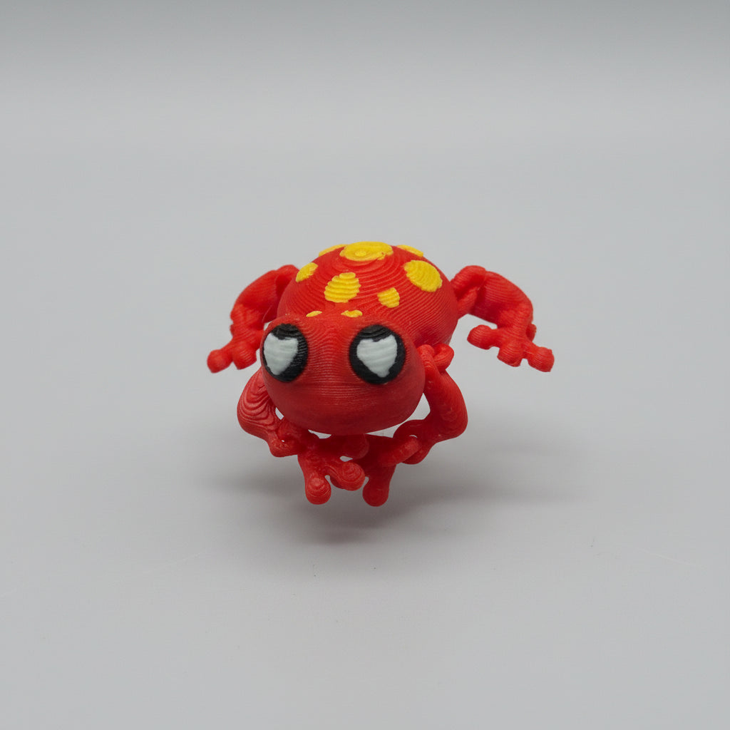 Red and yellow spider toy on a textured surface