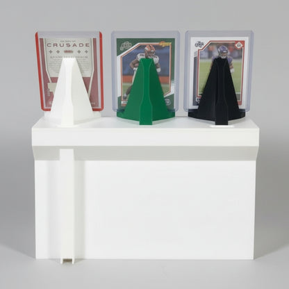 Three display stands in white, green, and black on a white surface with trading cards in the background.