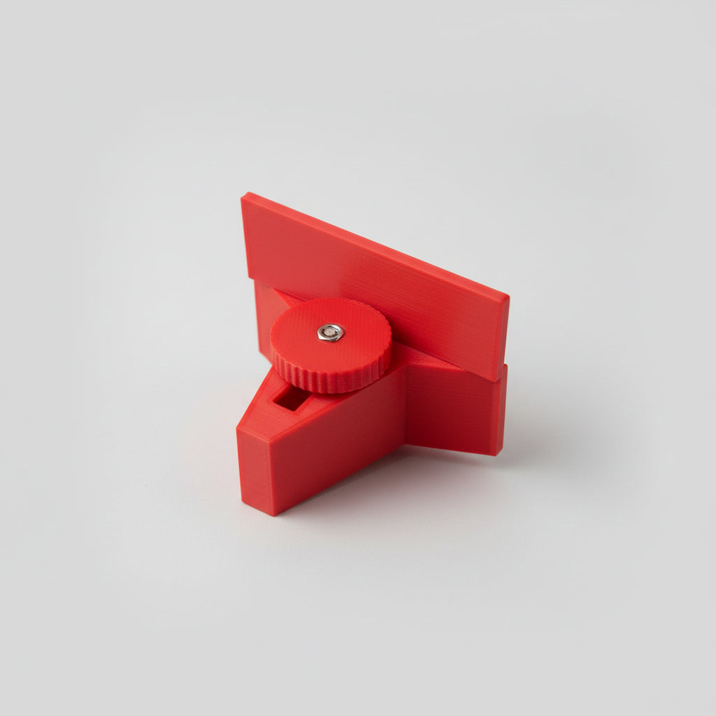 Red tool held by a hand on a wooden floor
