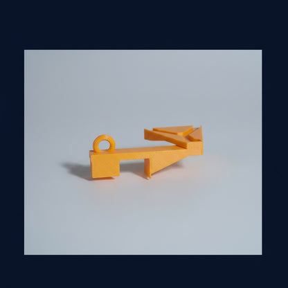 Yellow plastic tool on a dark surface with trading cards in the background