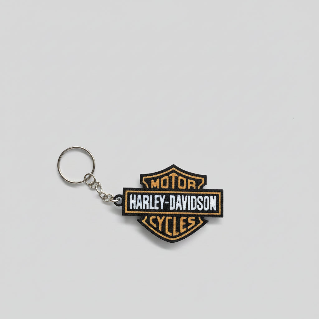 Harley-Davidson keychain on a dark surface with a 'Whatcha Printing' label in the background.