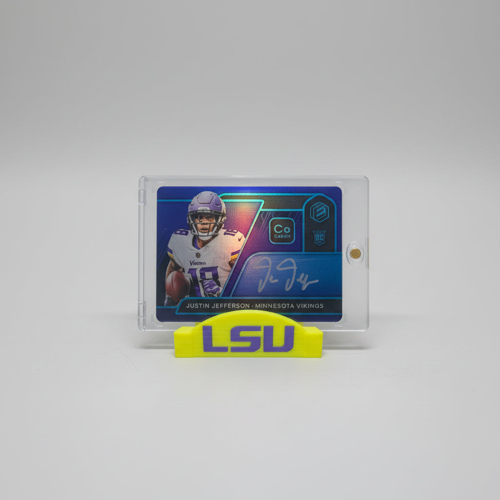 Trading card of a football player with a yellow highlighter on a laptop and marble surface