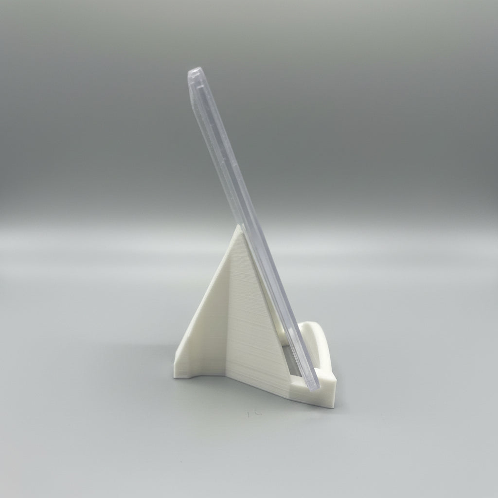 Clear phone case on a stand with a laptop in the background