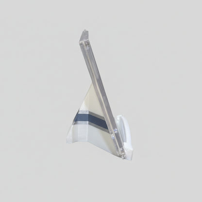 Clear plastic stand on a marble surface with a laptop in the background
