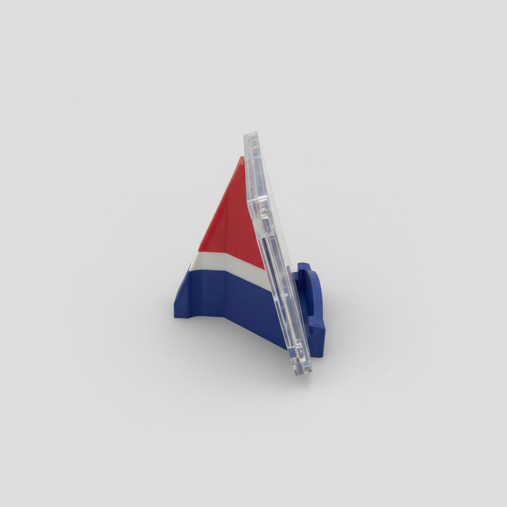 Pen with a 3D triangular flag design on a marble surface with a laptop in the background.