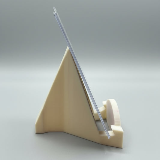 Clear plastic tool on a beige stand against a dark background