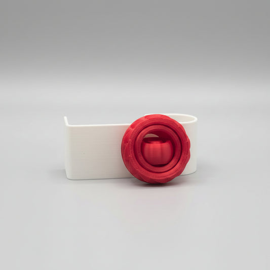 Red circular object on a white stand against a dark background