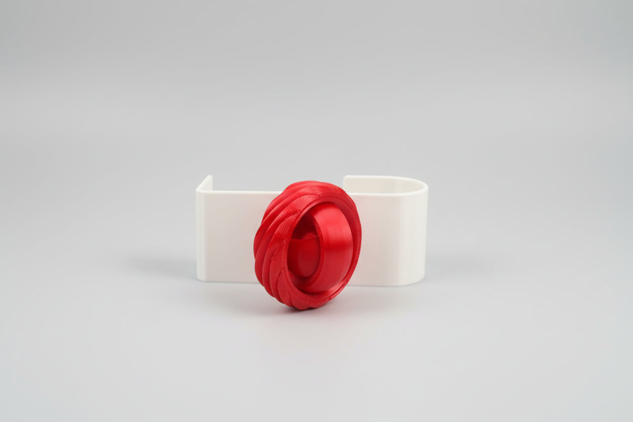 White decorative item with a red flower on a dark surface