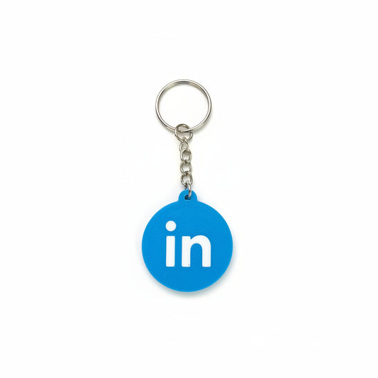 Blue keychain with LinkedIn logo on a textured black surface