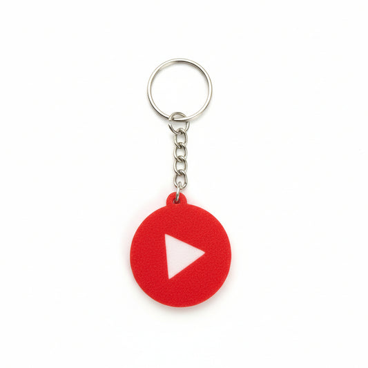 Red keychain with a white triangle on a black textured background