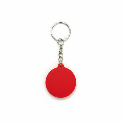 Red keychain with a metal ring on a carbon fiber background