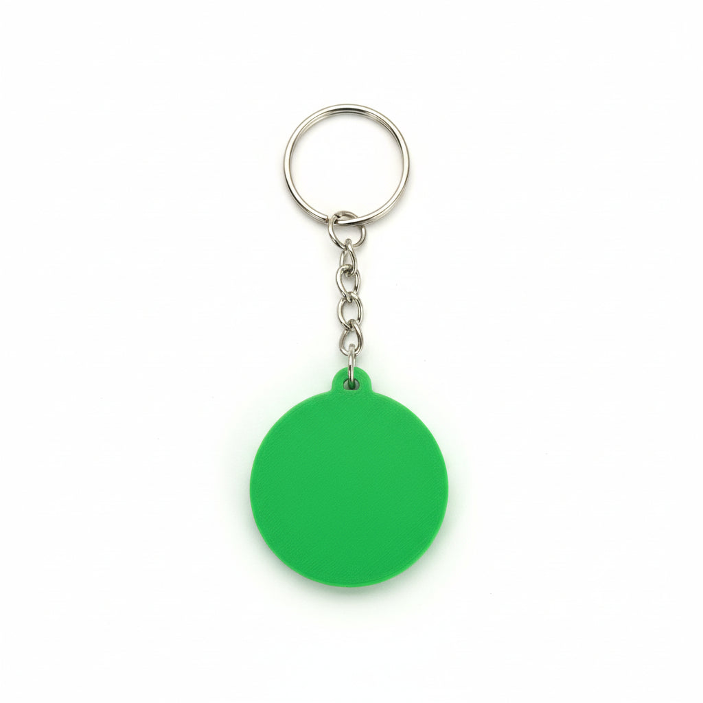 Green keychain with a metal ring on a dark textured background