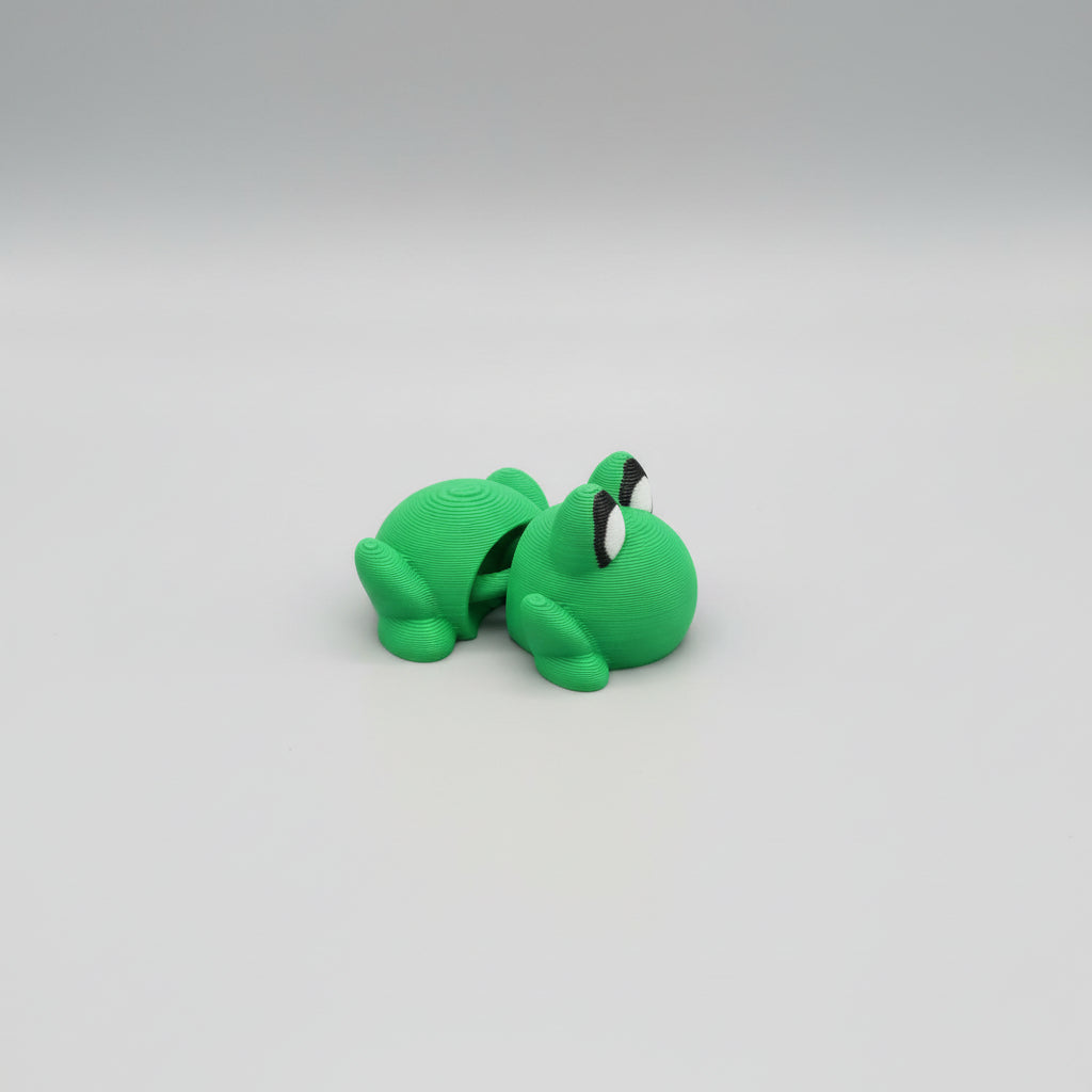 Green toy frog on a wooden surface