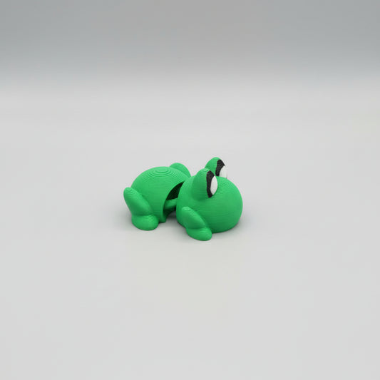 Green toy frog on a wooden surface