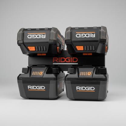 Four Ridgid battery packs stacked on a wooden surface.