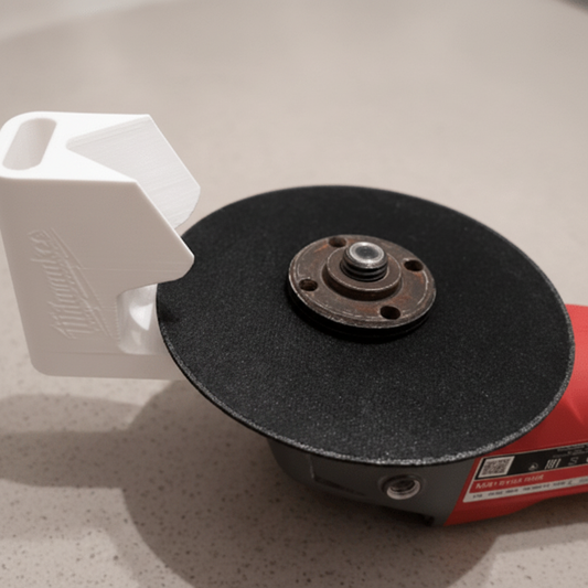 Person holding a white tool attachment near a black grinding wheel on a carpeted floor.