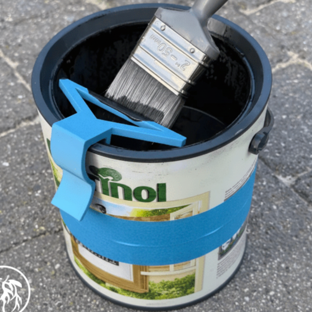 Paintbrush in a can of linseed oil with a blue clip on a textured surface