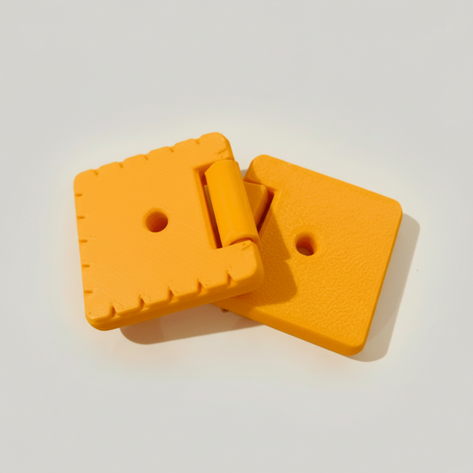 Two orange plastic clips on a white background with yellow square crackers.