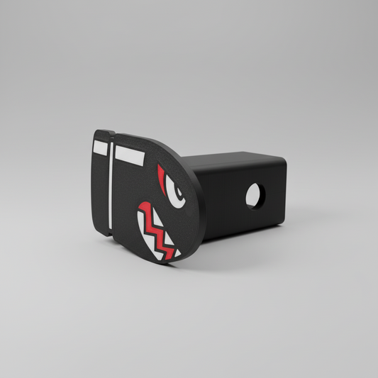 Black and red decorative hitch cover on a wooden surface with a neutral background