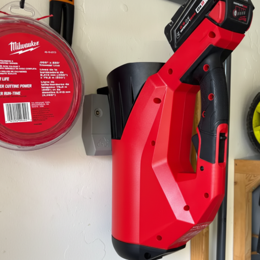 Red Milwaukee power tool on a white surface with various items around