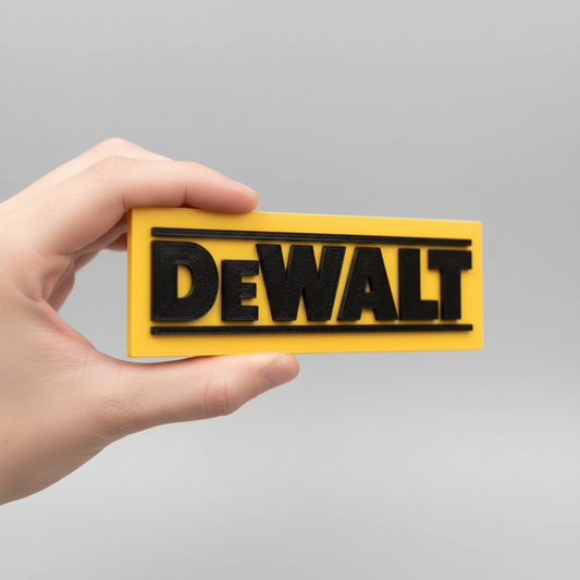 Hand holding a yellow Dewalt sign in front of a brick wall