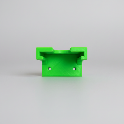 Green metal bracket on a wooden surface