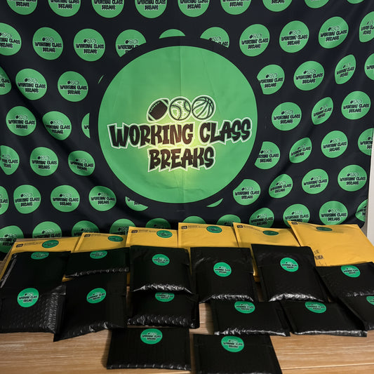 Black and yellow packages with green labels on a table against a backdrop with 'Working Class Breaks' branding.