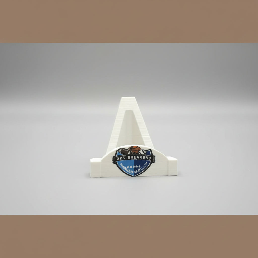 Small trophy with '225 Breakers' logo held in front of a larger logo on a wooden background