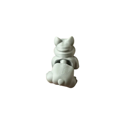 Small white ceramic figurine held in a hand on a wooden floor.