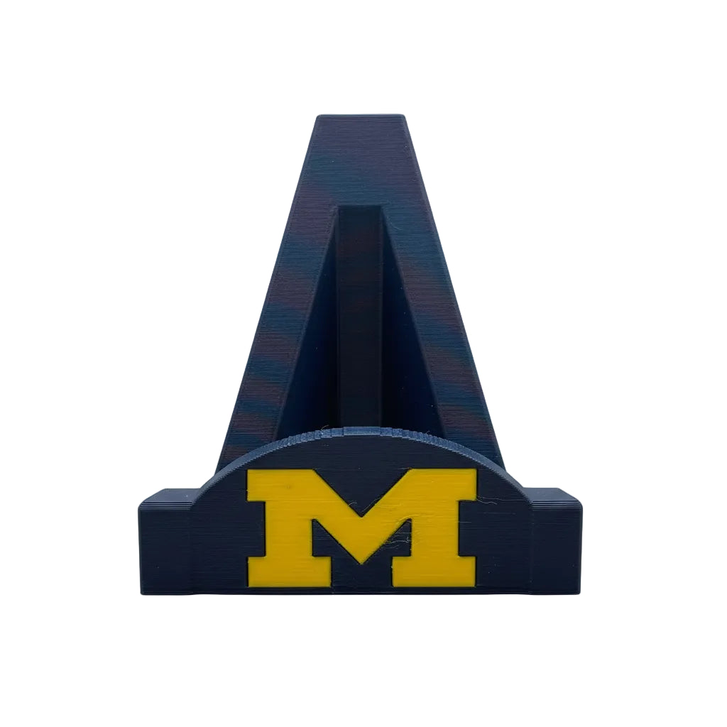 Blue letter 'A' with yellow 'M' on a white base against a textured gray background