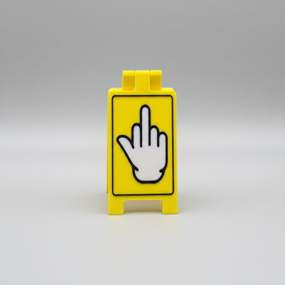 Yellow block with a black and white hand sign on a textured surface