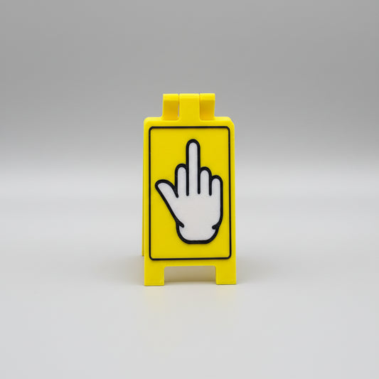 Yellow block with a black and white hand sign on a textured surface