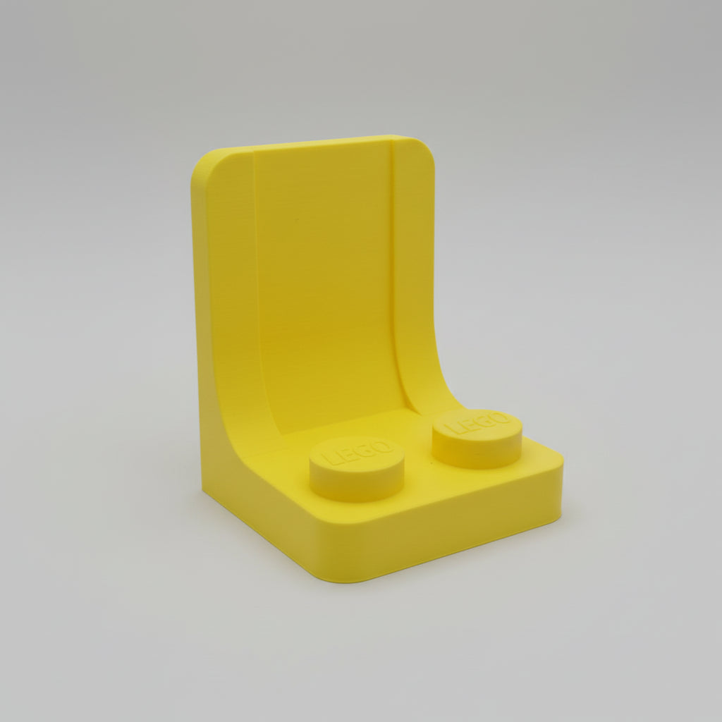 Yellow plastic block with two round protrusions on a textured white background