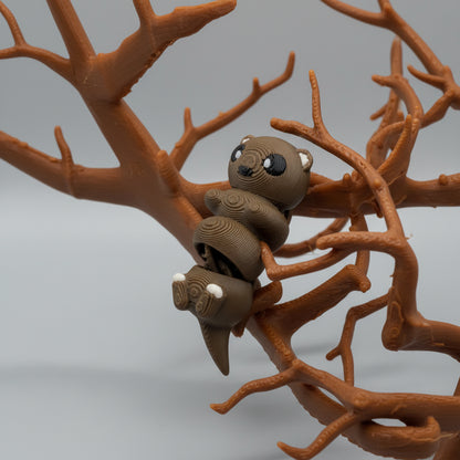 Small brown creature figurine on a textured surface with branches