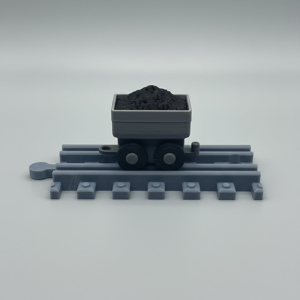 Toy train track with a cart full of coal on a reflective surface