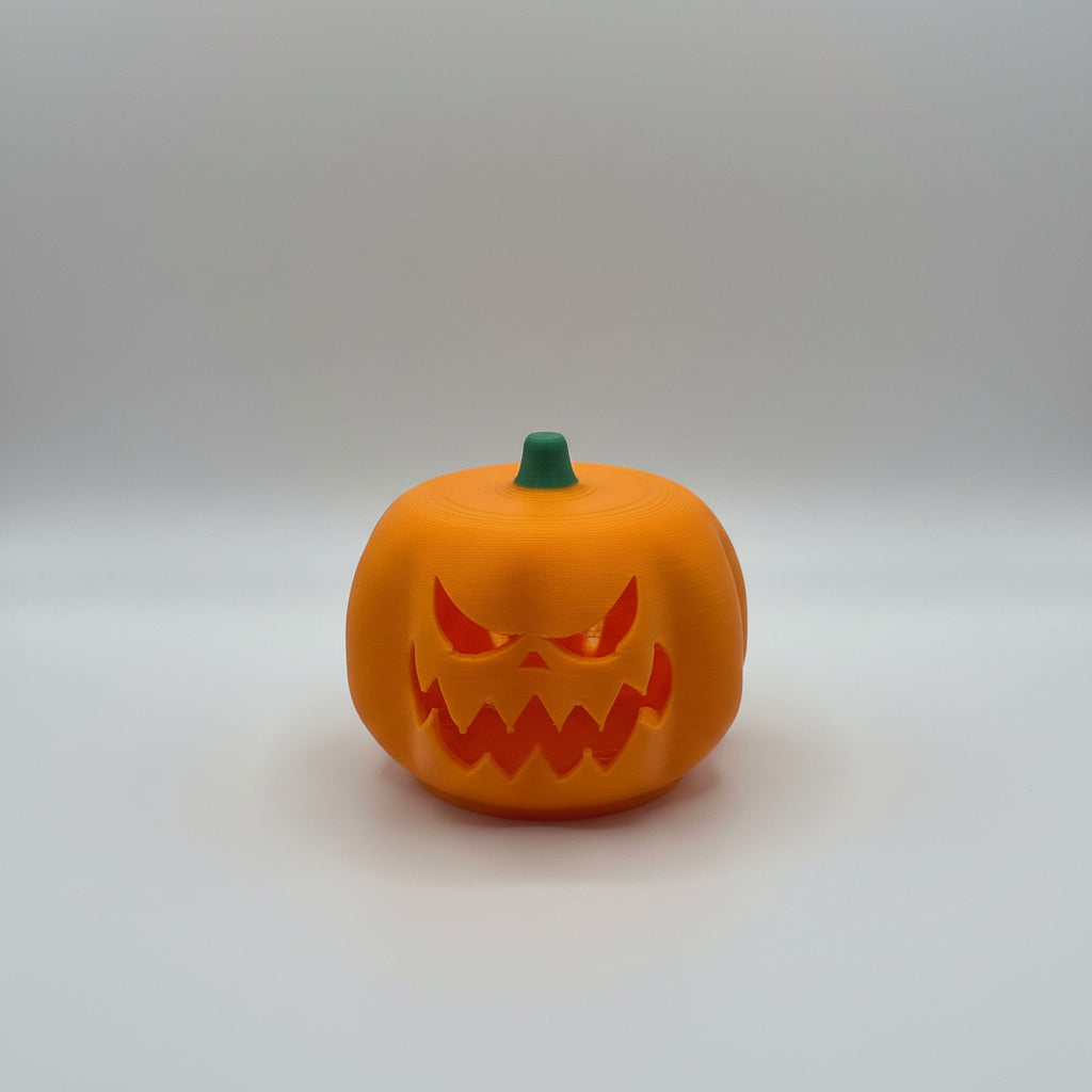 3D-printed pumpkin with a carved face on a white surface
