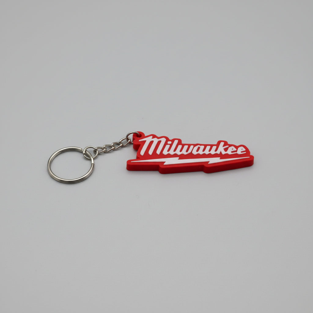 Red Milwaukee keychain on a textured gray surface
