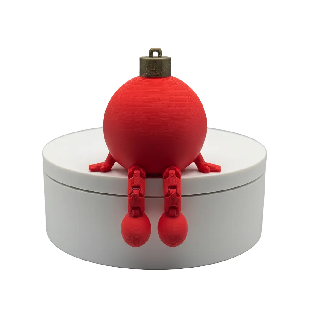 Red spherical object with legs on a white base against a textured gray background