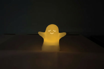 Ghost-shaped light emitting a yellow glow on a dark background