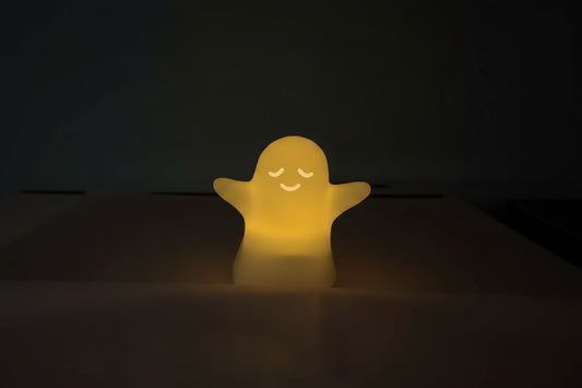 Ghost-shaped light emitting a yellow glow on a dark background