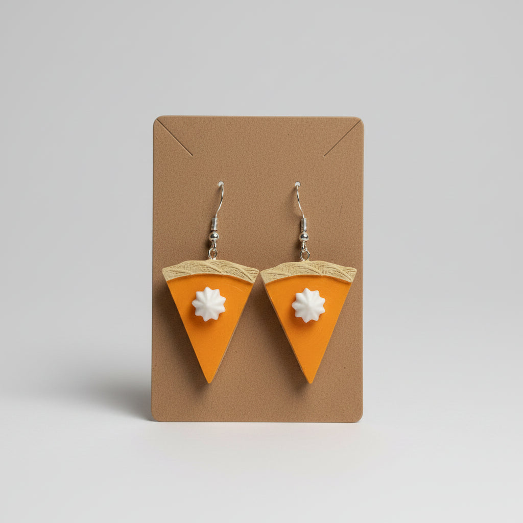 Pumpkin pie-shaped earrings on a brown card with floral background