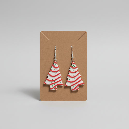 Red and white striped Christmas tree earrings on a brown card with floral background